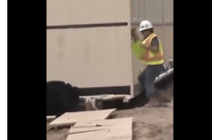 Construction worker at the corner of the outside of a building